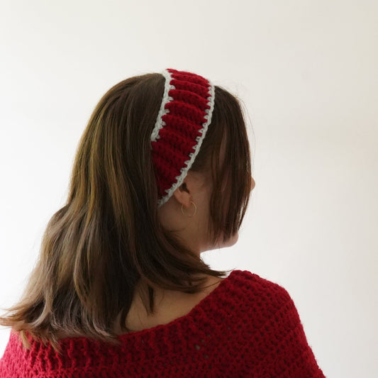 Person wearing a red sweater and red headband with a white background