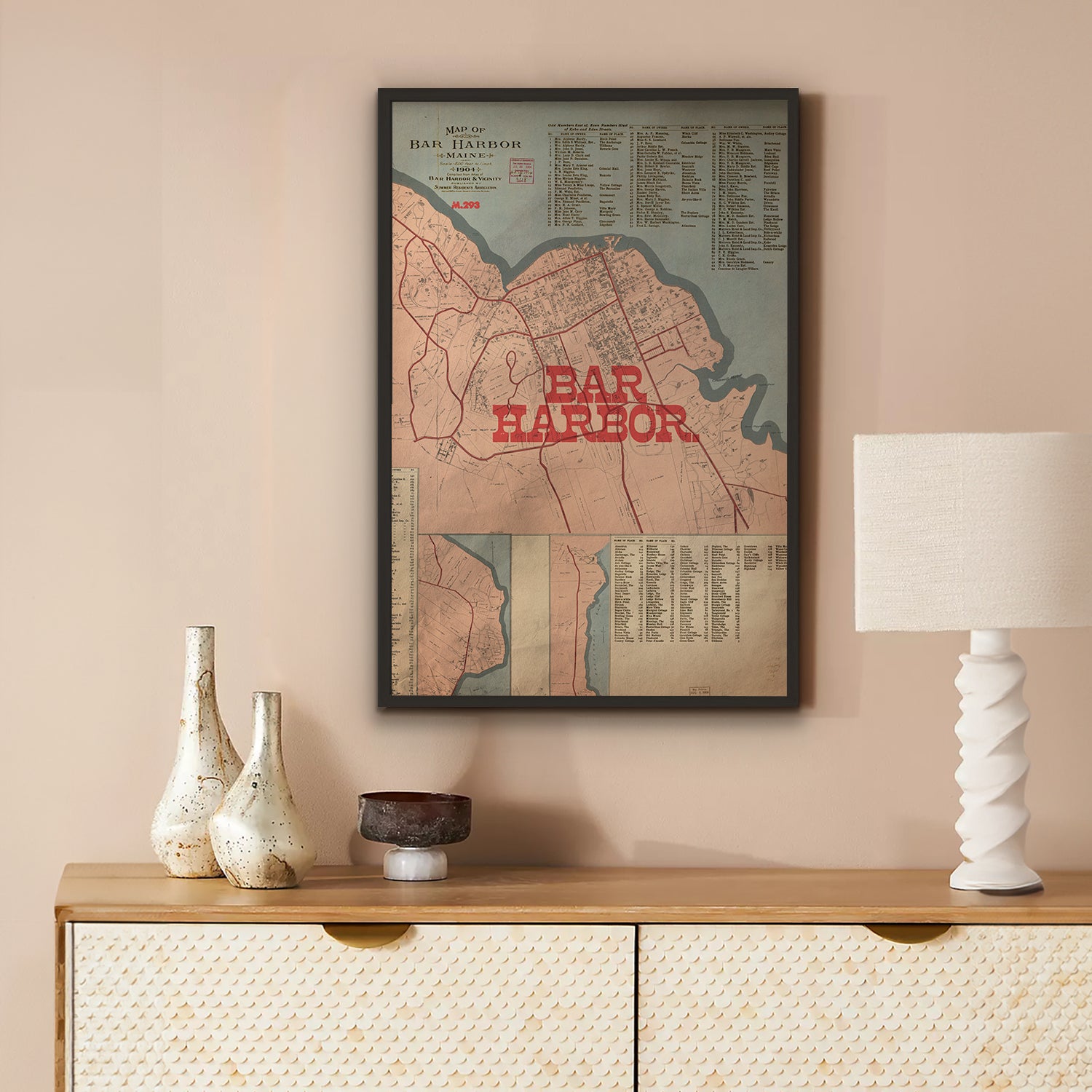 Framed map of Bar Harbor on a wall above a wooden console table with decorative items.