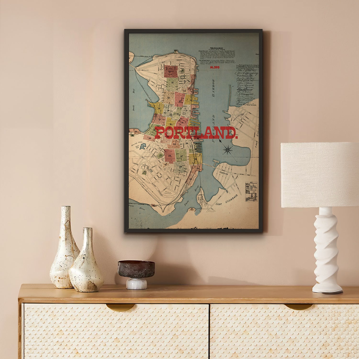 Framed map of Portland on a wall above a wooden console table with decorative items.