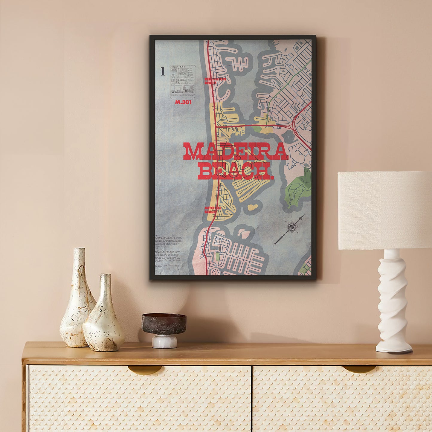 Framed map of Madeira Beach on a wall above a wooden console table with decorative items.