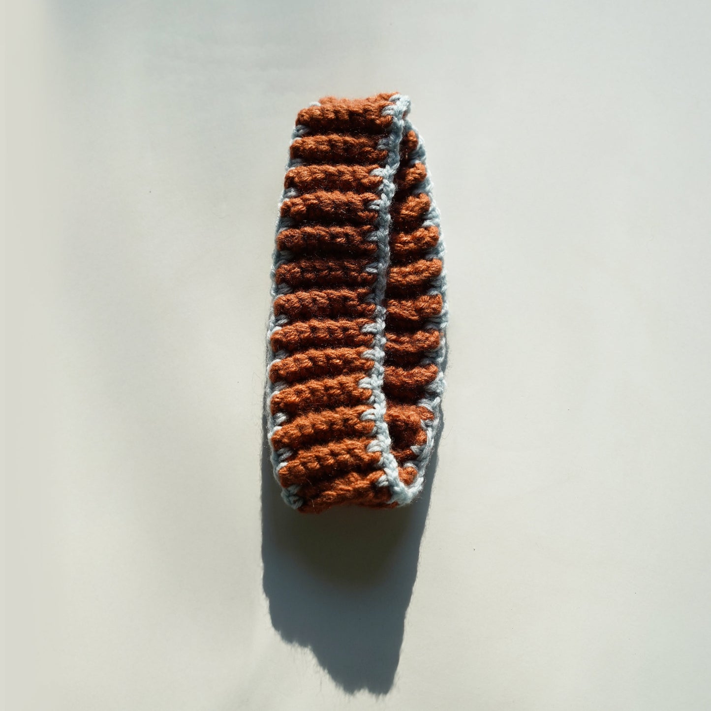 Crocheted bheadband with brown and gray pattern on a light background