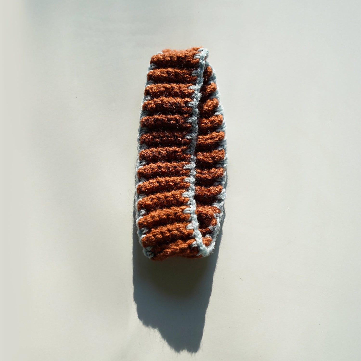 Crocheted bheadband with brown and gray pattern on a light background