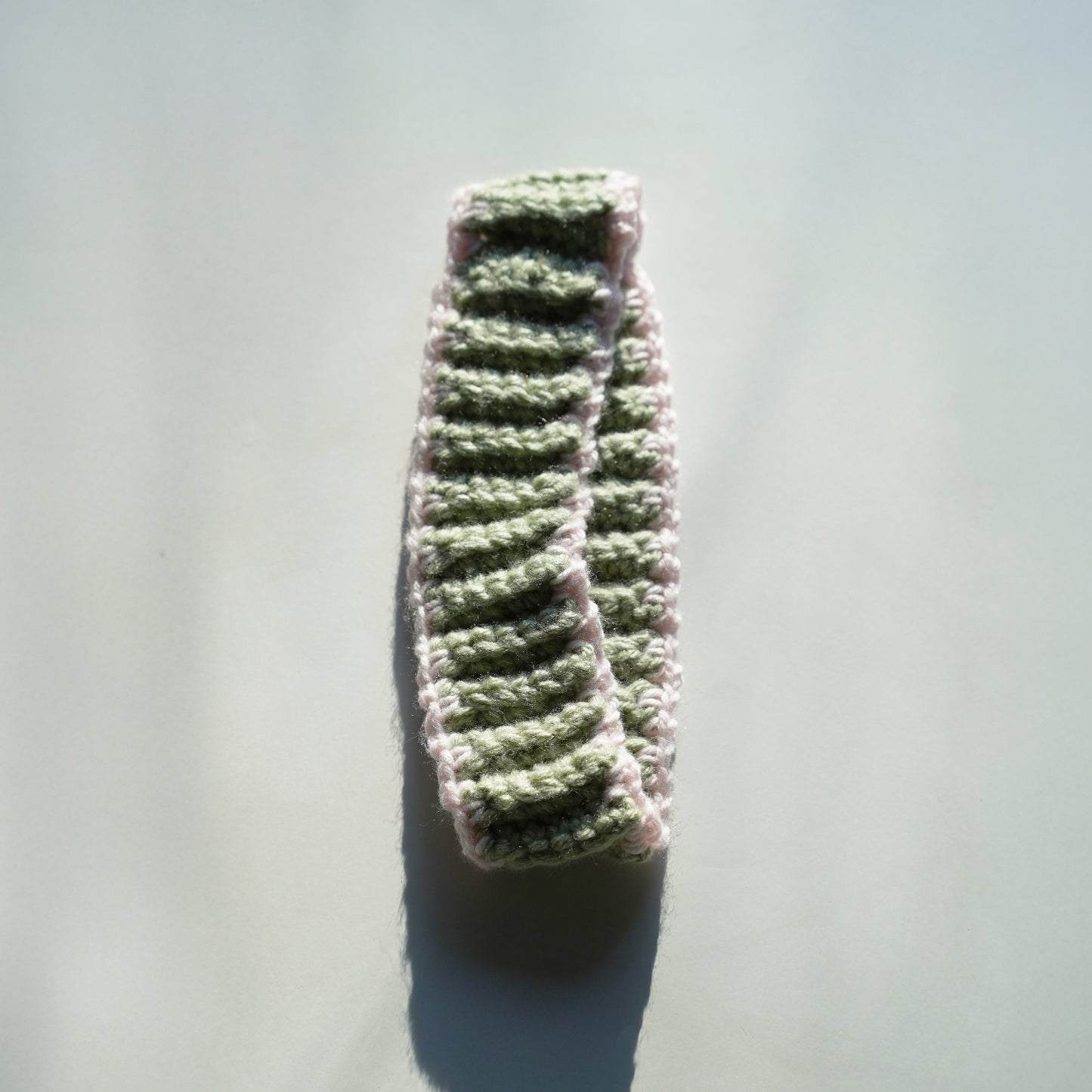 Crocheted headband on a light gray background