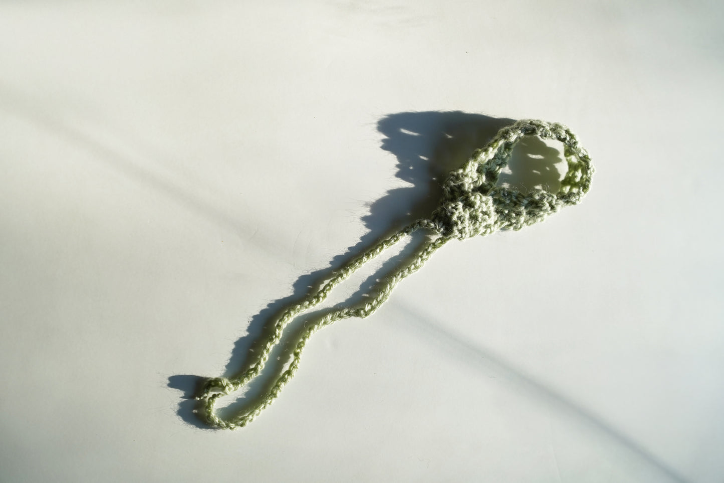 Green knitted headband on a light gray background