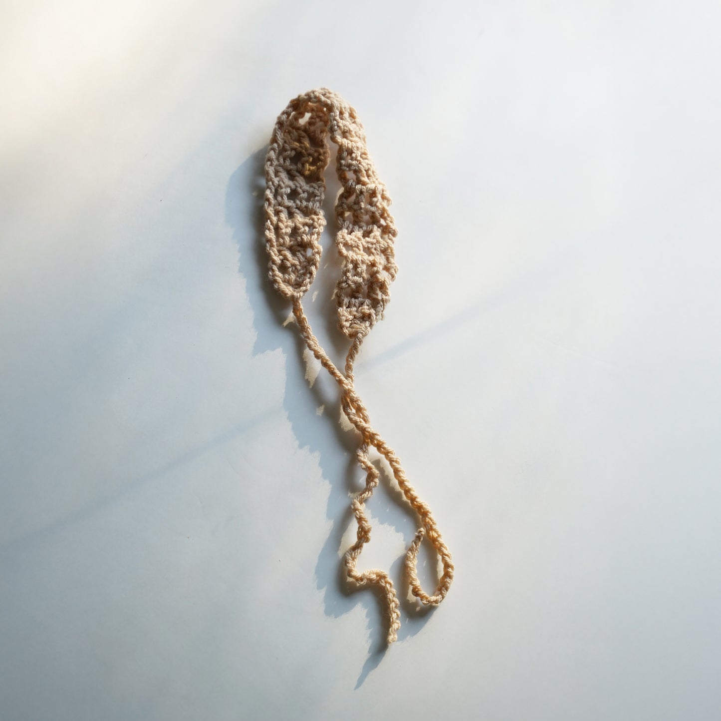 Crocheted headband on a light gray background