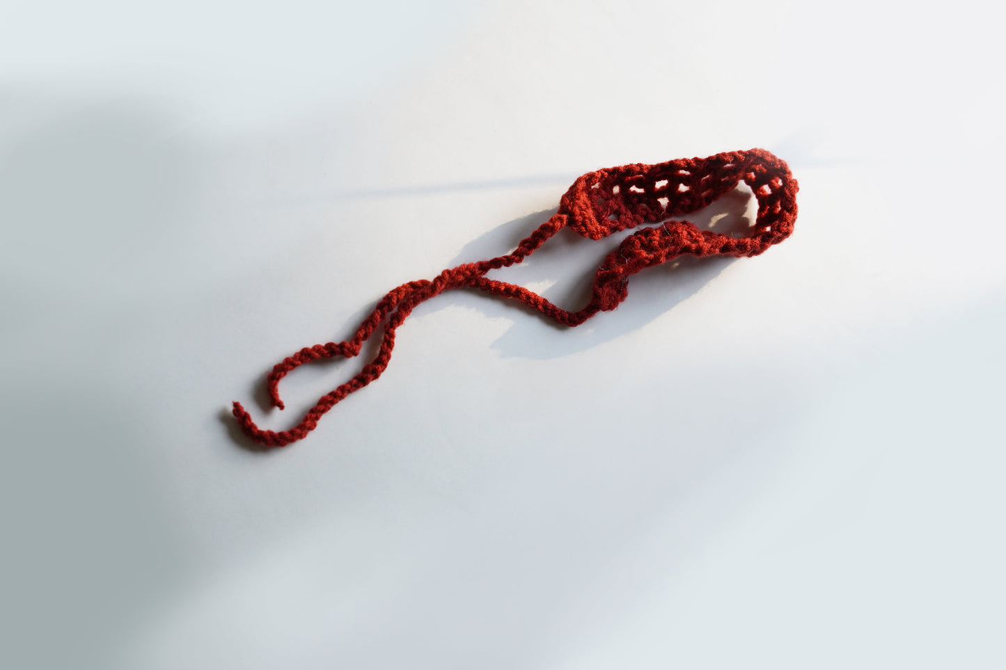 Red crochet headband on a white background