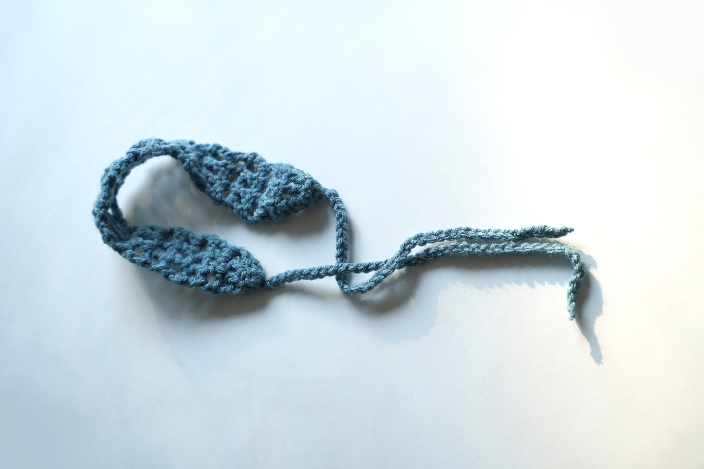 Blue knitted headband on a white background