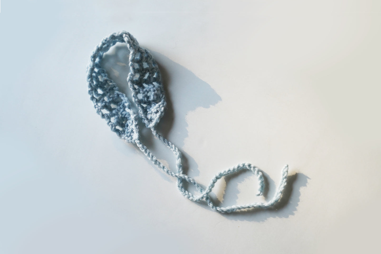 Blue knitted headband on a light gray background