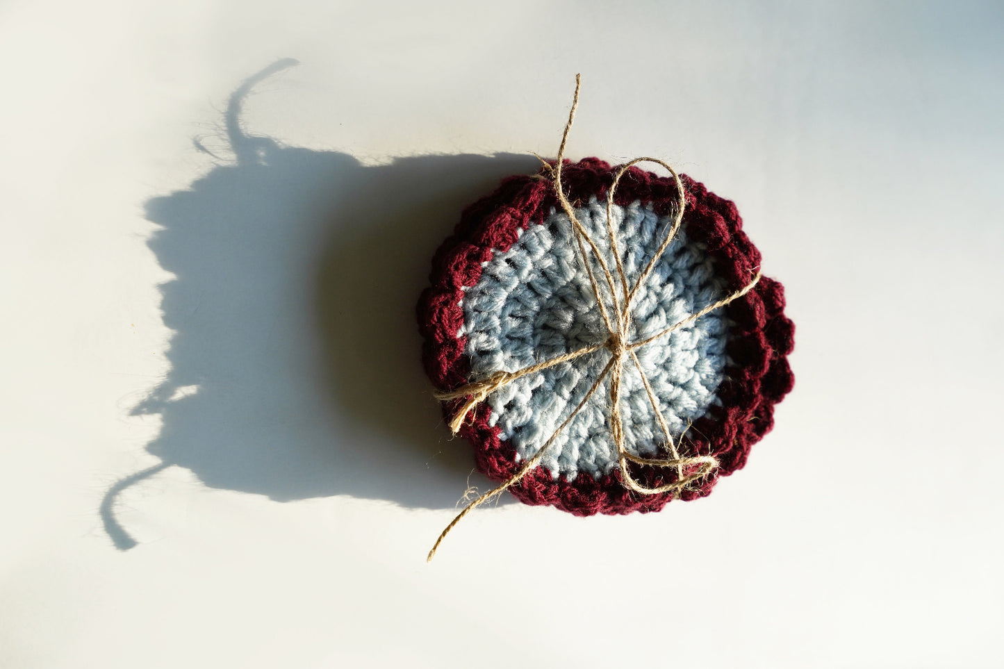Crocheted coasters with red and blue center on a light background