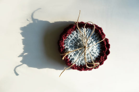 Crocheted coasters with red and blue center on a light background